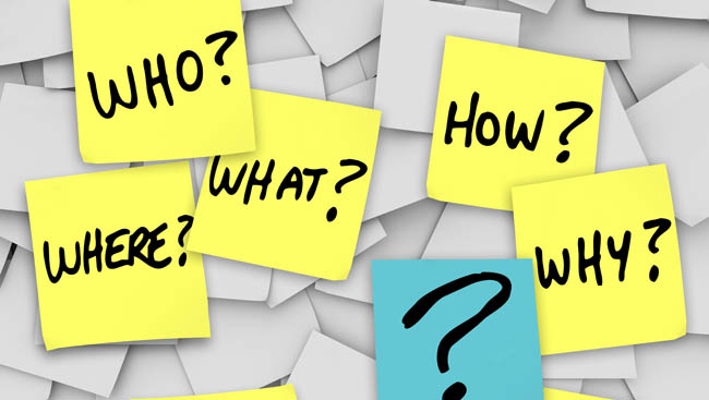 Many sticky notes with questions like who, what, when, where, how and why, and a question mark, all posted on an office noteboard to represent confusion in communincation